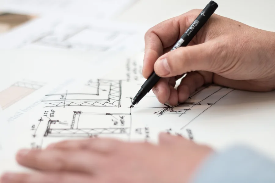 A designer sketching a layout over the site plan