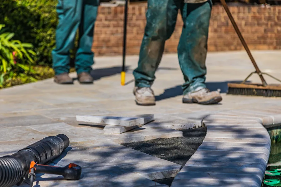 A crew laying paving on site